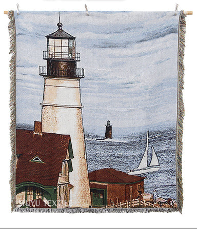 Woven blanket with a lighthouse design, featuring a sailboat and coastal scene.